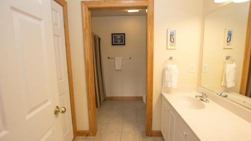 La salle de bains est pourvue d'un lavabo et d'un miroir. dans l'établissement OS11K, Hook, Line Skipper- Oceanside, Dogs Welcome, Private Pool, Rec Room, à Corolla
