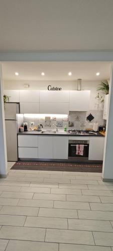 a kitchen with white cabinets and a counter top at Casa Ricci in Acilia