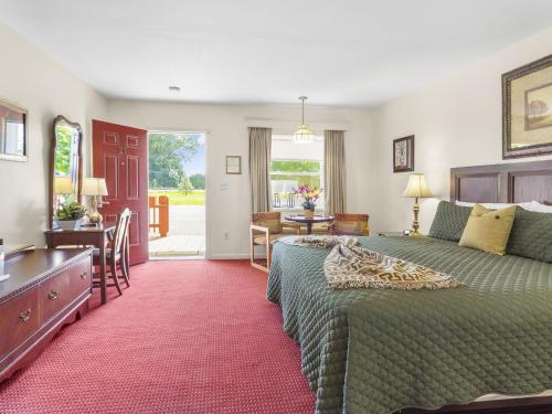 Habitación de hotel con cama, escritorio y habitación en Blue Spruce Inn & Suites, en Valatie