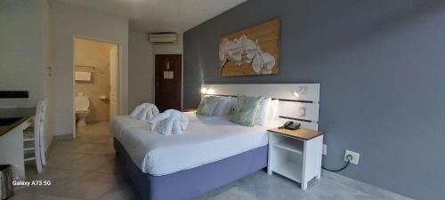 1 dormitorio con 1 cama grande con sábanas y almohadas blancas en Elephant Lake Hotel, en St Lucia