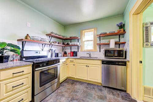 a kitchen with yellow cabinets and stainless steel appliances at Canary Cottage-brighten your stay-central NW OKC in Oklahoma City