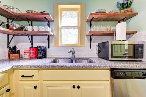 a kitchen with a sink and a microwave at Canary Cottage-brighten your stay-central NW OKC in Oklahoma City