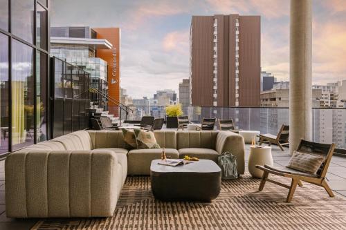 Sonder Maisonneuve في مونتريال: غرفة معيشة مع أريكة وطاولات على مبنى