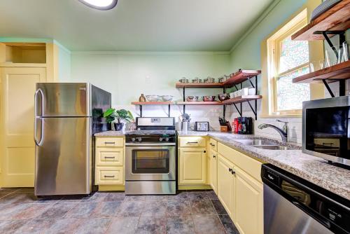 a kitchen with yellow cabinets and a stainless steel refrigerator at Canary Cottage-brighten your stay-central NW OKC in Oklahoma City