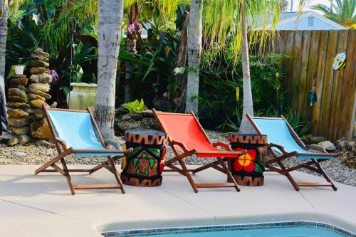 um grupo de três cadeiras sentadas ao lado de uma piscina em Tropical Island Escape Near Disney, Beach, Cruise em Merritt Island