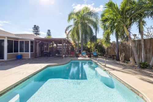 a swimming pool in front of a house with palm trees at Tropical Island Escape Near Disney, Beach, Cruise in Merritt Island