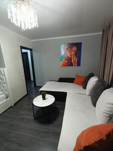 uma sala de estar com duas camas e uma mesa em Квартира в центре с гостиничным сервисом. em Petropavl