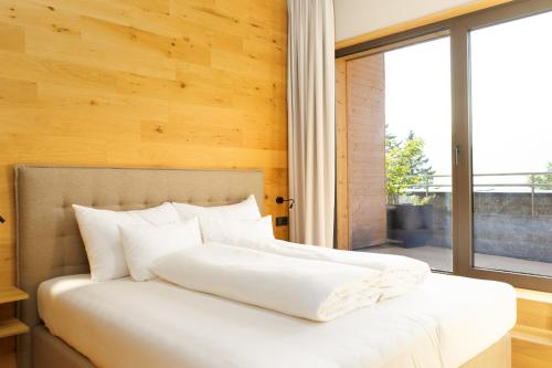 - une chambre avec un lit blanc et une grande fenêtre dans l'établissement Heimat 1495m Appartement TYP 2, à Schröcken