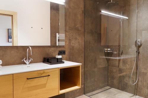 y baño con lavabo y ducha. en Heimat 1495m Appartement TYP 2, en Schröcken