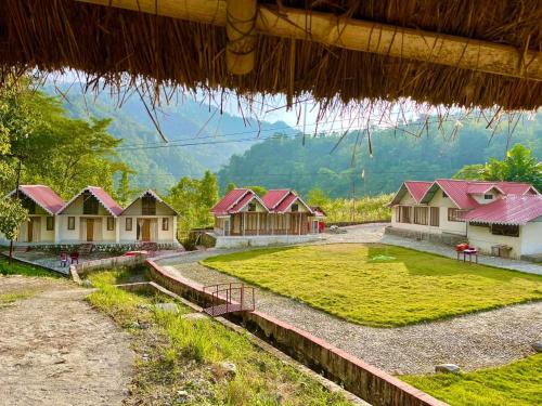 a row of houses with red roofs in a field at Rio De Vallis Eco Resort in Kalimpong