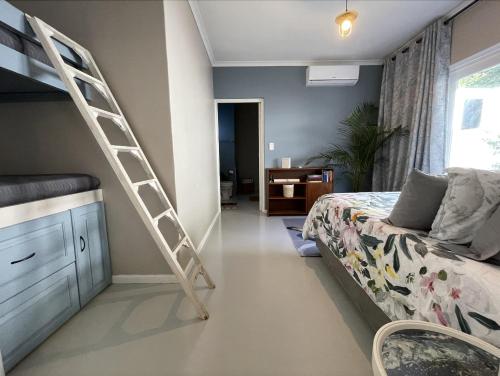 a bedroom with a bunk bed and a ladder at Villa Songo, Estuary Country Estate - INVERTER & RENOVATED in Port Edward