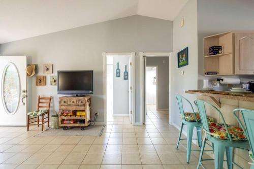 a kitchen with a table and chairs and a tv at Tropical Island Escape Near Disney, Beach, Cruise in Merritt Island