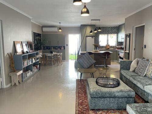 sala de estar con sofá, sillas y mesa en Villa Songo, Estuary Country Estate, INVERTER & RENOVATED en Port Edward
