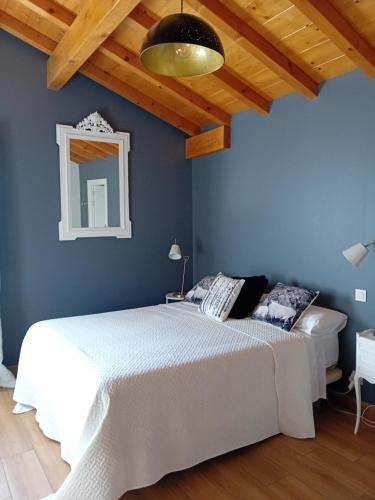 a bedroom with a white bed and a blue wall at ATALOZTI Maison d'hôtes ST JEAN PIED DE PORT in Ascarat