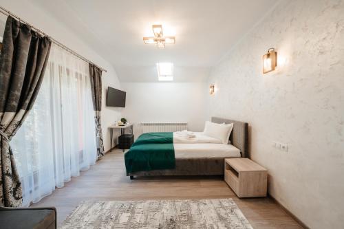 um quarto com uma cama e uma grande janela em Casa Diana em Vatra Dornei
