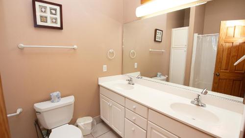 une salle de bain avec un lavabo, des toilettes et un miroir dans l'établissement Oceanside, Hot Tub, Private Pool, OS1B, Always Unforgettable, à Corolla