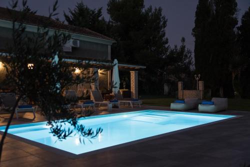 a swimming pool in a yard at night at The Green House Villa (with private pool) Corfu in Sidari