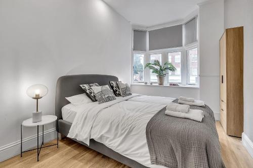 Un dormitorio blanco con una cama grande y una ventana en The Pembroke en Londres