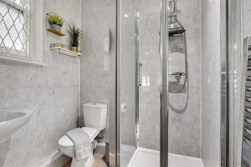 a bathroom with a shower and a toilet and a sink at The Pembroke in London