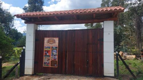 una puerta de madera con un cartel delante en Cabaña campestre #1 en Ráquira