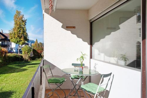 a patio with a table and chairs on a balcony at Paulas Ferienwohnung in Füssen