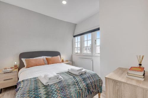 1 dormitorio con 1 cama con 2 toallas en The Phillimore en Londres