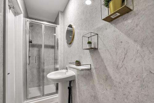 a white bathroom with a sink and a shower at The Phillimore in London
