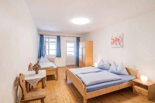 a small bedroom with two beds and a table at Rieplhof in Vipiteno