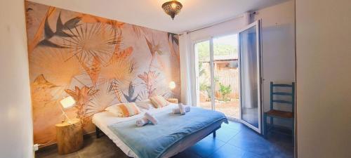 ein Schlafzimmer mit einem Bett mit Blumenwand in der Unterkunft Appt Bruscaghju 6 pers 5 min rivière à pieds 15 min plage en voiture in Sainte-Lucie de Porto-Vecchio