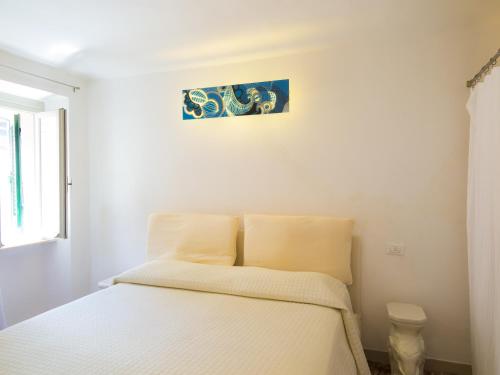 een slaapkamer met een bed met witte lakens bij Appartamenti Dietro L'Angolo in Portoferraio