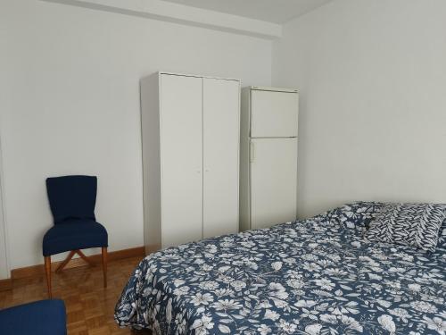 a bedroom with a bed and a blue chair at Habitación luminosas en Vista Alegre in Madrid