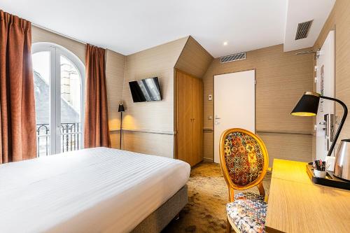 a bedroom with a bed and a desk and a chair at Hotel La Manufacture in Paris