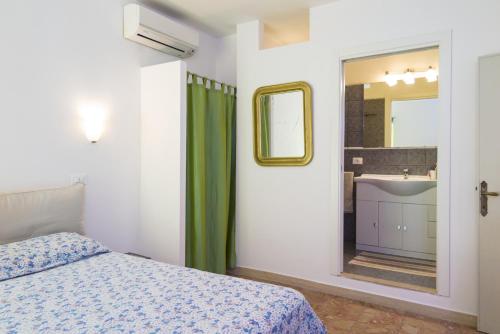 a bedroom with a bed and a mirror and a sink at Appartamenti Dietro L'Angolo in Portoferraio