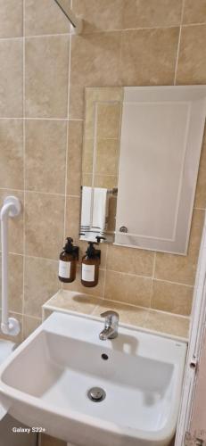 a bathroom with a white sink and a mirror at Archillects - Entire Two Bedroom Comfy House in Glasgow