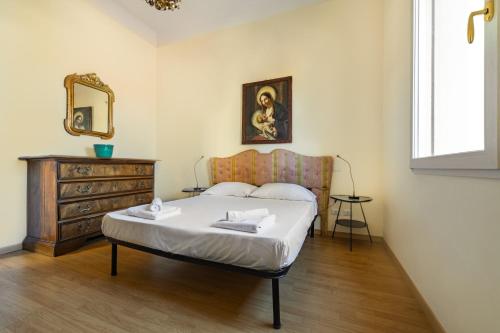 a bedroom with a bed and a dresser and a mirror at GetTheKey Attico delle Torri in Bologna
