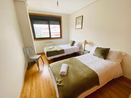 奧波里尼奧的住宿－Orballo，一间卧室设有两张床和窗户。