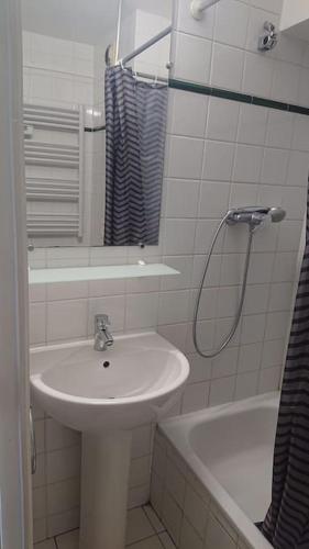 une salle de bain avec un lavabo, une baignoire et une douche dans l'établissement 10 min walk to metro Line 1, ApartHotel La Défense, à Courbevoie
