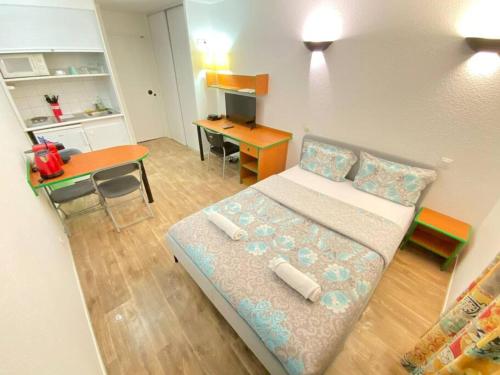 une petite pièce avec un lit et une table dans l'établissement 10 min walk to metro Line 1, ApartHotel La Défense, à Courbevoie
