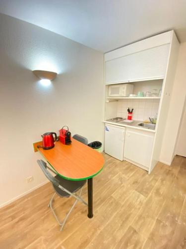 - une table et des chaises dans une pièce avec cuisine dans l'établissement 10 min walk to metro Line 1, ApartHotel La Défense, à Courbevoie