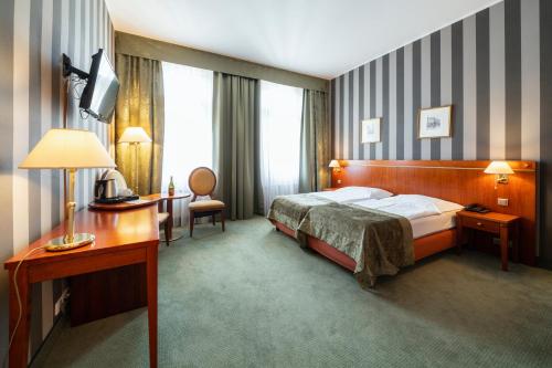 a hotel room with a bed and a desk at Hotel Raffaello Prague in Prague