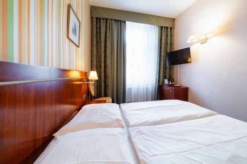a hotel room with two beds and a television at Hotel Raffaello Prague in Prague