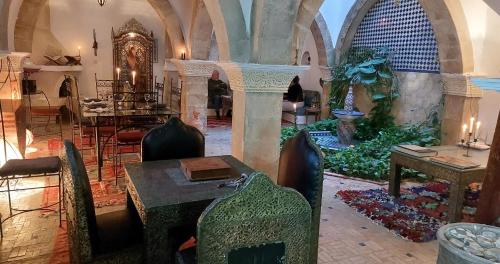 a room with a table and chairs in a building at Dar Rahaothello in Essaouira