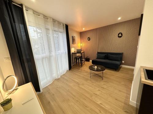 a living room with a black couch and a table at Résidence République in Dijon