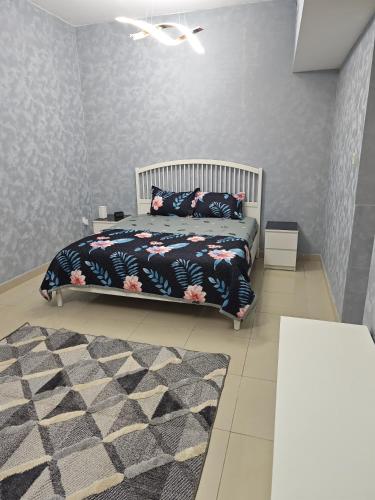 a bedroom with a bed and a rug at Pearl Apartment in Ajman 
