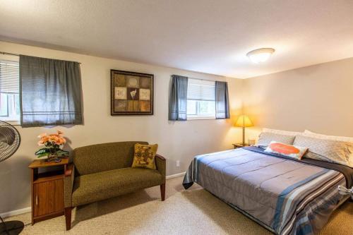 een slaapkamer met een bed en een stoel bij Emerald City Studio Suite in Eugene