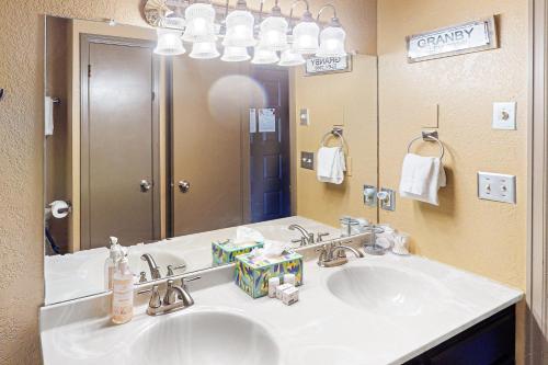 Silver Creek - Door 418 في غرانبي: حمام مع حوض ومرآة كبيرة