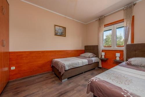 ein Hotelzimmer mit 2 Betten und einem Fenster in der Unterkunft Villa Marijana, rural,private pool,playground in Gorica