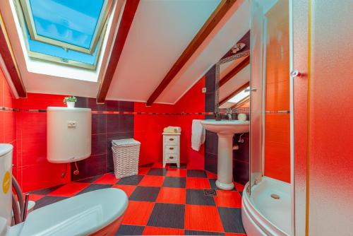 ein Badezimmer mit roten Wänden und einem karierten Boden in der Unterkunft Villa Marijana, rural,private pool,playground in Gorica