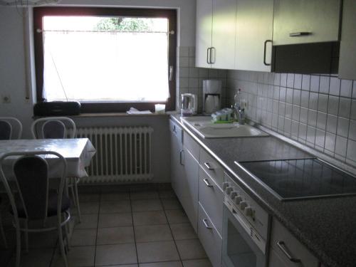 a kitchen with a sink and a window and a table at Ferienwohnung Kulla in Albstadt