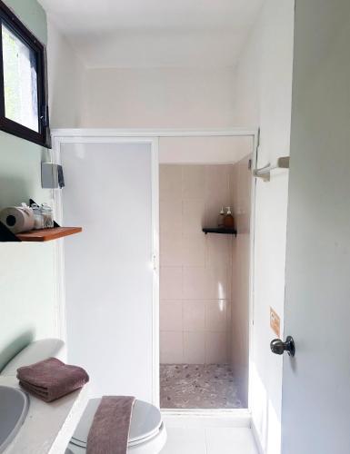 a bathroom with a shower with a toilet and a sink at Sirenas Caribbean Rooms Holbox in Holbox Island